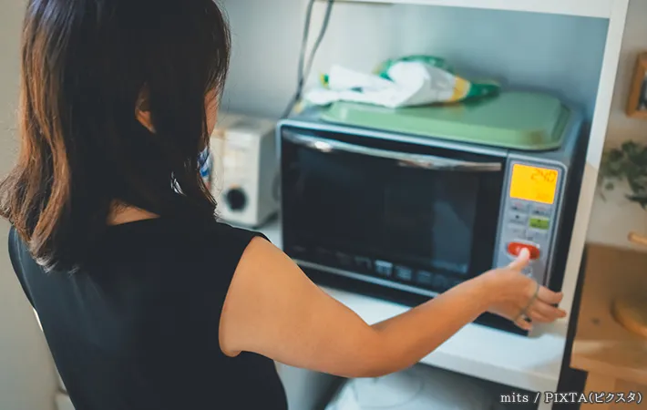 電子レンジと女性の写真