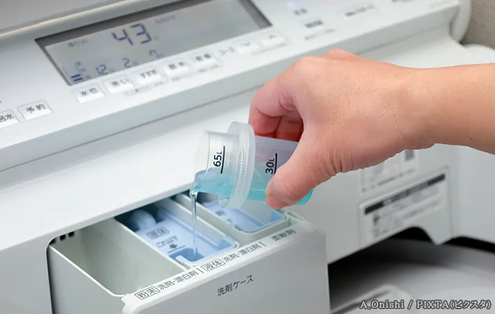洗剤を洗濯機に入れる写真