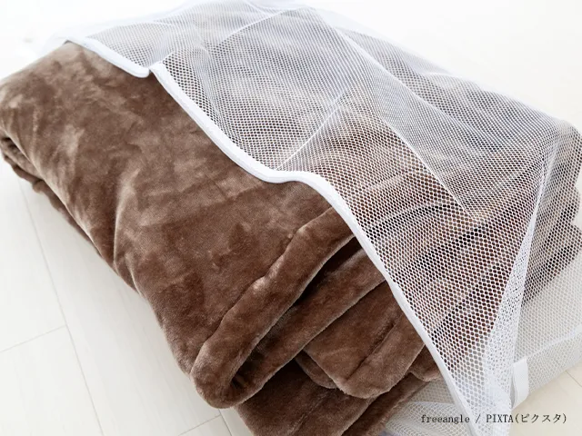 毛布を『屏風だたみ』にしてネットに入れる場面