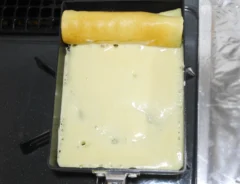 卵焼き器で生地を巻いていく（撮影：grapeフード編集部）