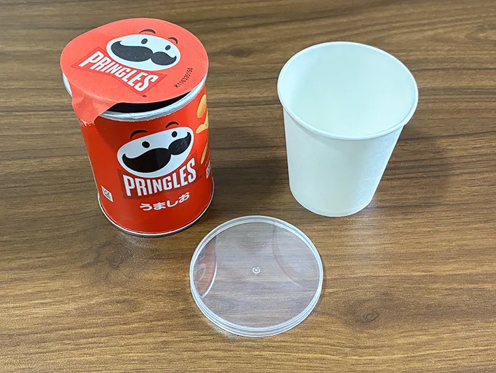 机に置かれたプリングルズの容器と、紙コップ（撮影：grapeライフハック編集部）