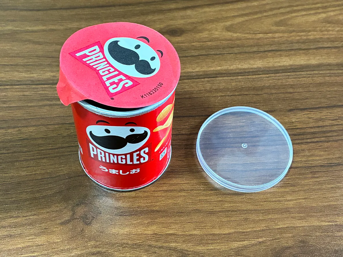 机に置かれたプリングルズの容器と蓋（撮影：grapeライフハック編集部）