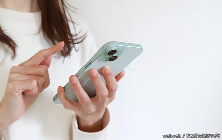 スマホを持つ女性の写真