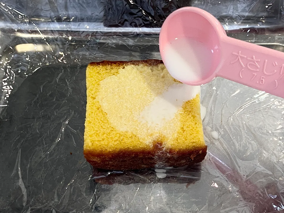 カステラに牛乳をかけた場面（撮影：grapeフード編集部）