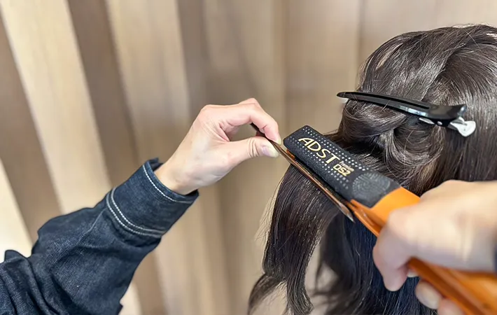 ヘアアイロンを使っている写真