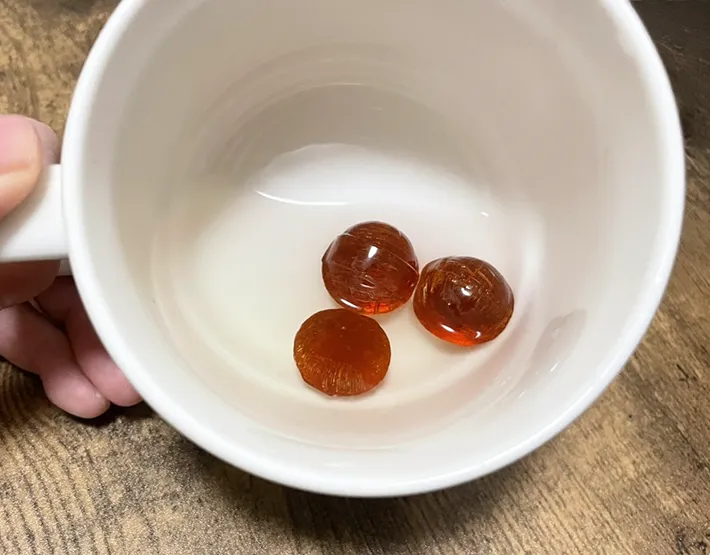 『カンロ飴』3個と水を入れた器の写真撮影：grapeフード編集部