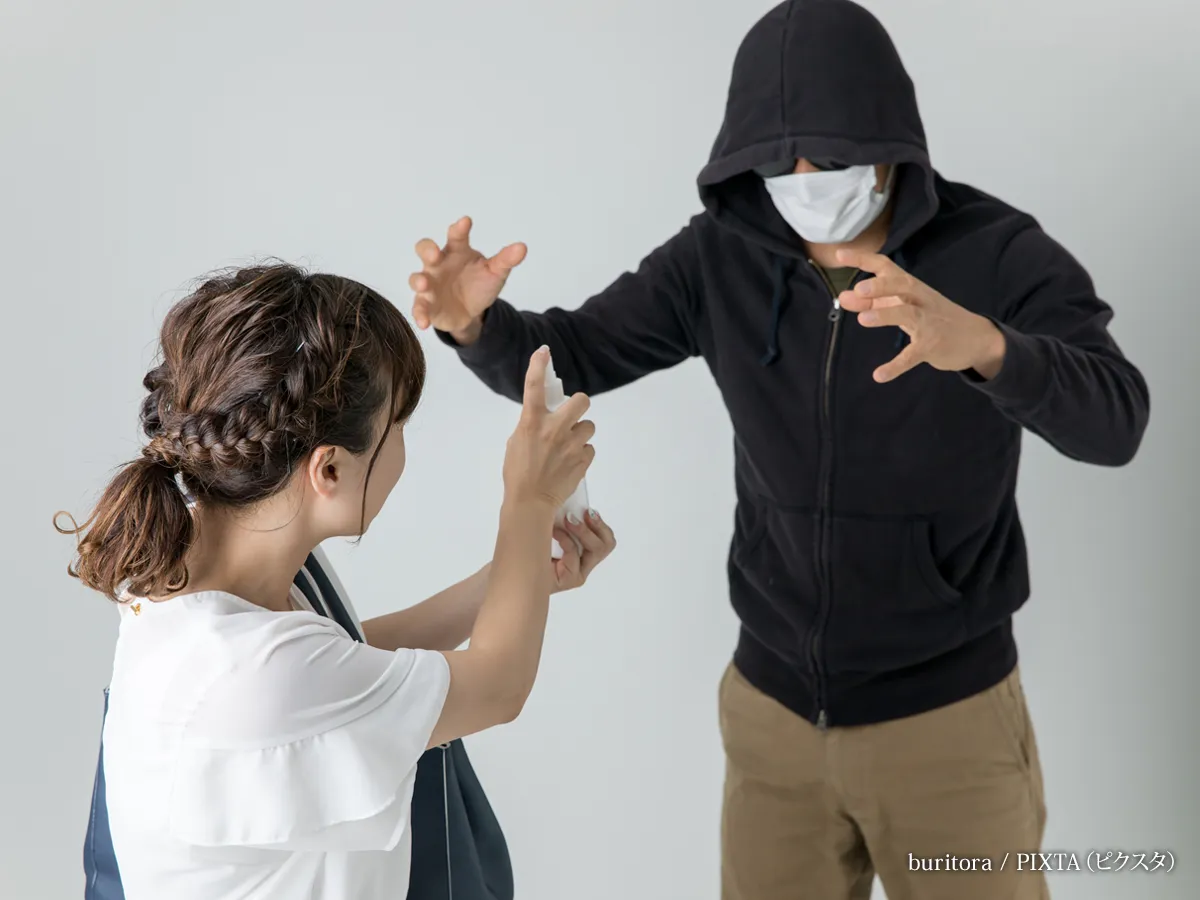 『犯罪者に防犯スプレーをかける女性』の写真