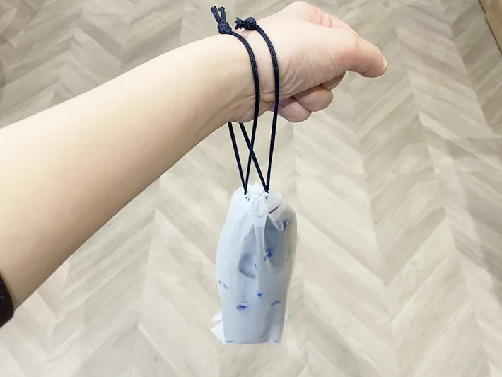 折りたたみ傘巾着ケースを腕に通した写真（撮影：grapeライフハック編集部）