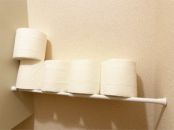 トイレに設置したつっぱり棒の上にトイレットペーパーを置いている画像（撮影：grapeライフハック編集部）