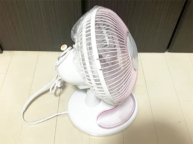 『セリア』のシャワーキャップを扇風機にかぶせる場面（撮影：grapeライフハック編集部）
