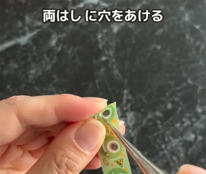 マスキングテープを貼ったクリアファイルに穴を開ける画像