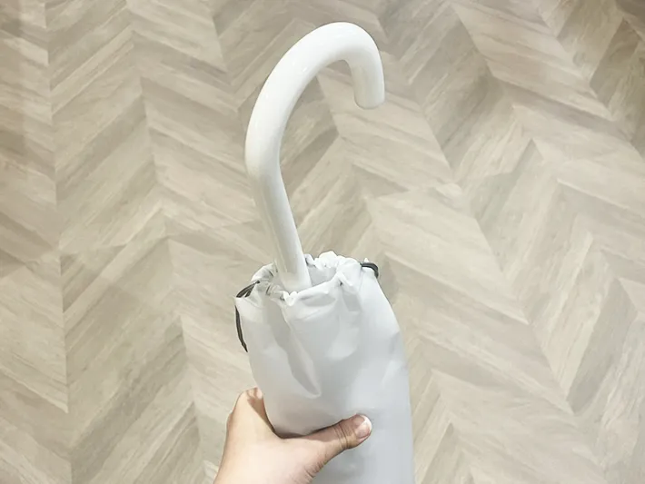 傘の肩掛けカバー入りの傘を持つ写真（撮影：grapeライフハック編集部）
