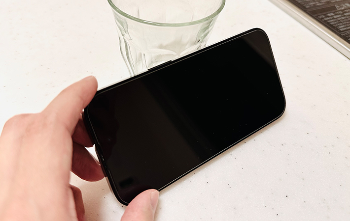 スマホをコップに立てかけようとしている写真（撮影：grapeライフハック編集部）