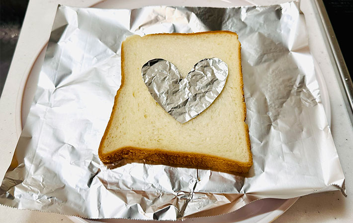 食パンにハート型のアルミホイルをのせている写真（撮影：grapeフード編集部）