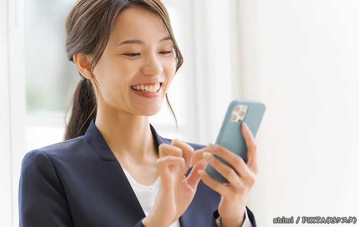 スマホを持つ女性の写真