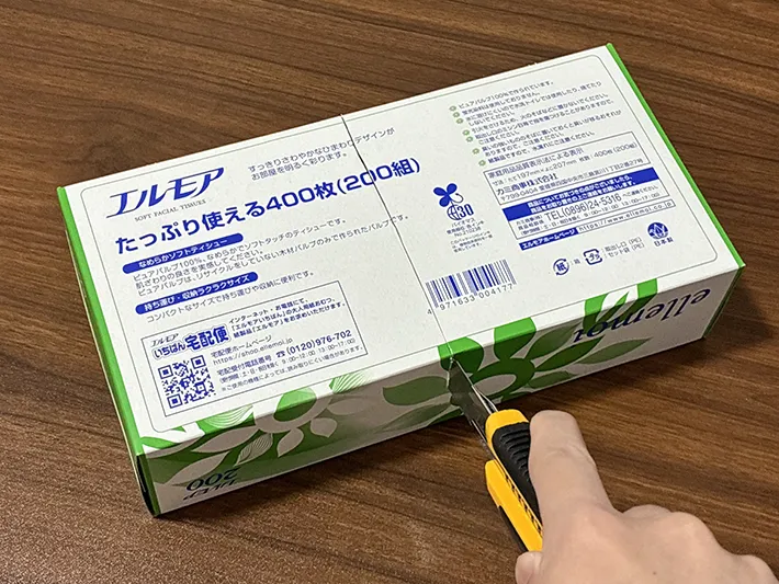 カッターで空き箱に一直線の切れ込みを入れる場面（撮影：grapeライフハック編集部）