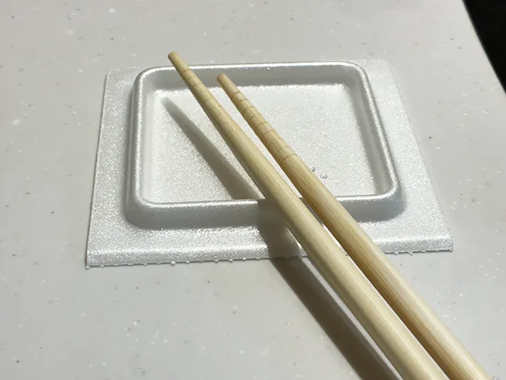 菜箸を乗せた納豆パックの蓋（撮影：grapeライフハック編集部）
