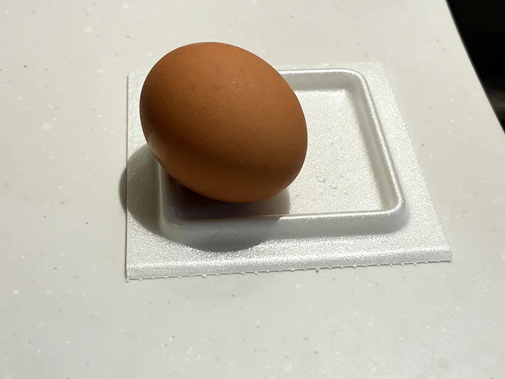 生卵を乗せた納豆パックの蓋（撮影：grapeライフハック編集部）