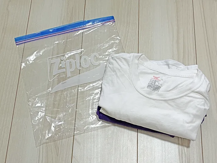 床に置かれたジッパー袋とTシャツ、半ズボン（撮影：grapeライフハック編集部）