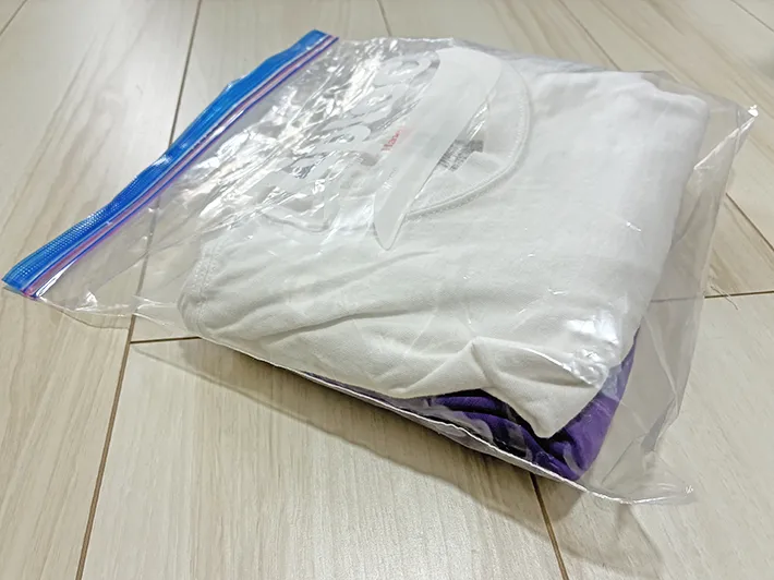 服と半ズボンを入れてふくらんだジッパー袋（撮影：grapeライフハック編集部）