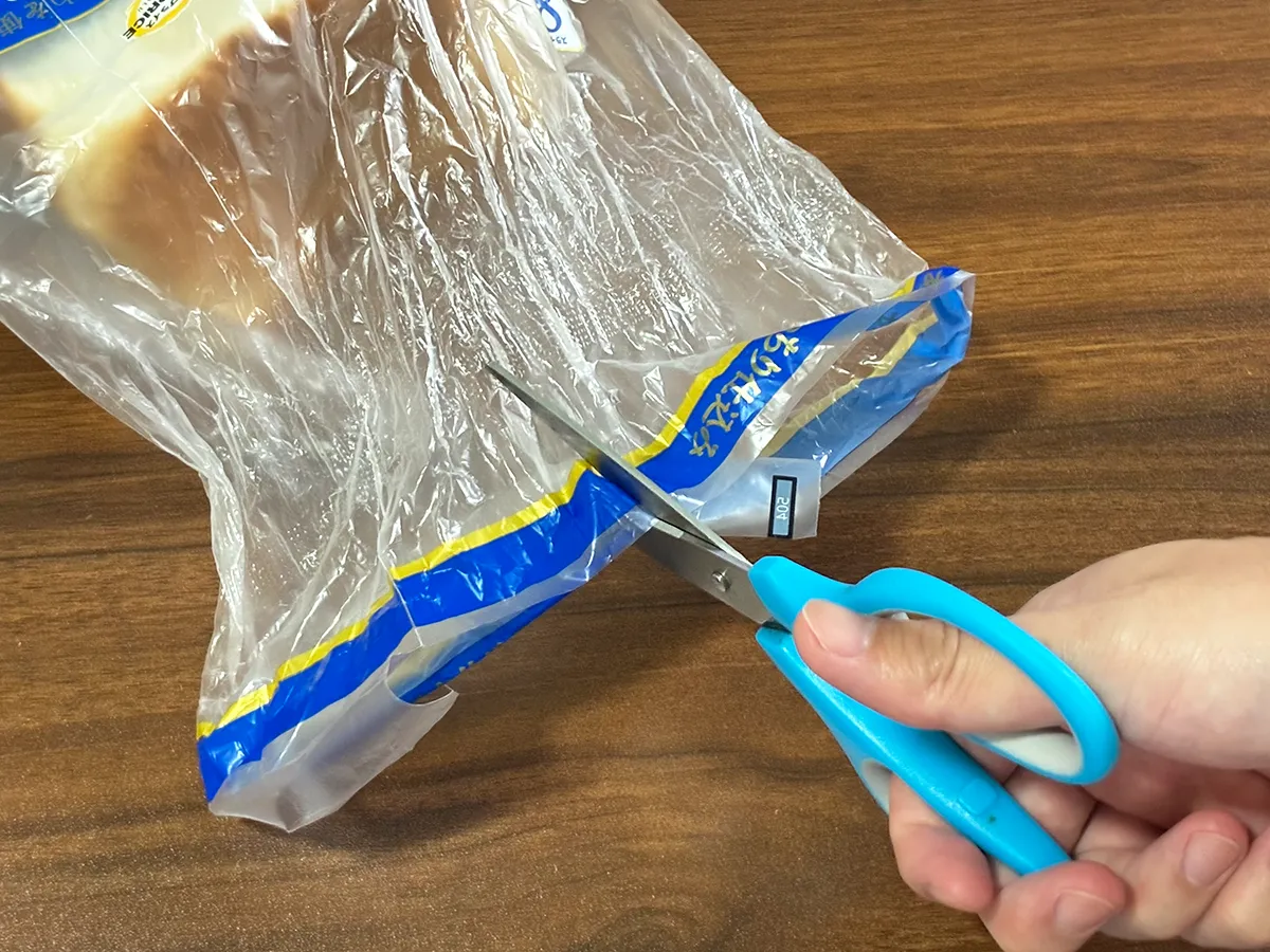 食パンの袋にハサミで切れ込みを入れる場面（撮影：grapeライフハック編集部）
