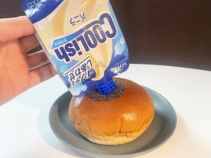 クーリッシュをあんぱんに挿す写真（撮影：grapeフード編集部）