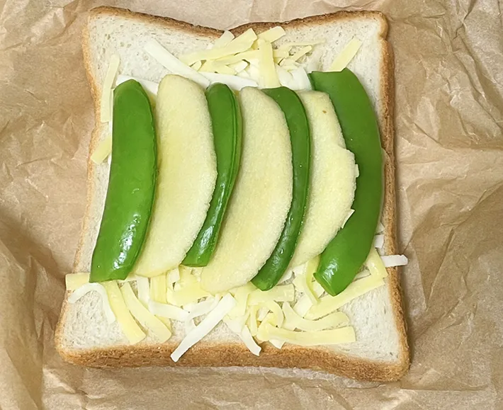 スナップエンドウとリンゴを交互に並べて食パンの上にのせた写真（撮影：grapeフード編集部）