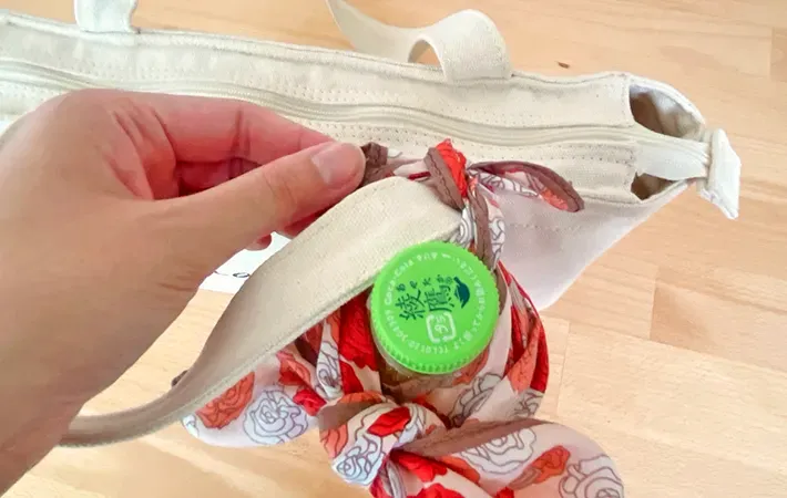 ペットボトルホルダーをバッグに取りつける写真（撮影：grapeライフハック編集部）