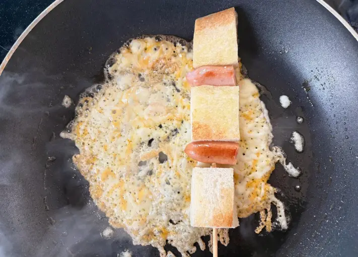 食パンとウインナーを刺した竹串をチーズの上に乗せた画像（撮影：エニママ）