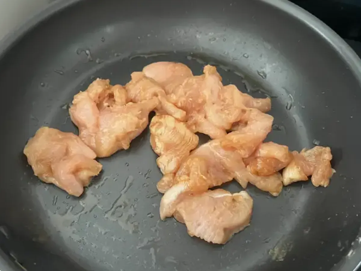 フライパンにごま油を引き、鶏むね肉を炒めている画像(撮影:エニママ)