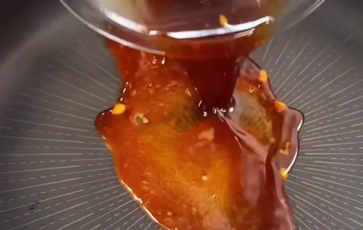 照り焼きソースをフライパンに投入している画像