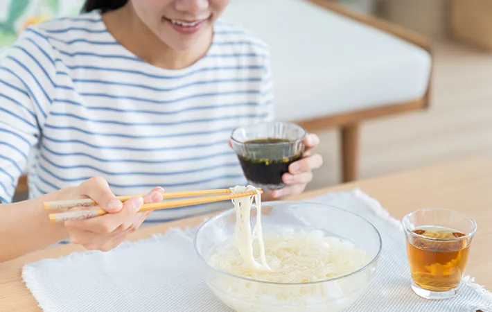 そうめんを食べる女性の写真