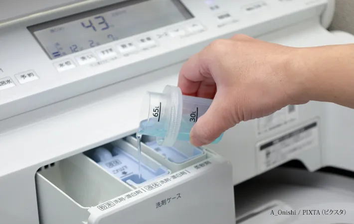 『洗濯機に液体洗剤を入れる』写真