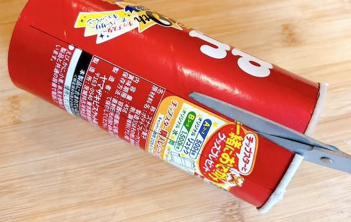 チップスターの箱をハサミで切る画像（撮影：キジカク）
