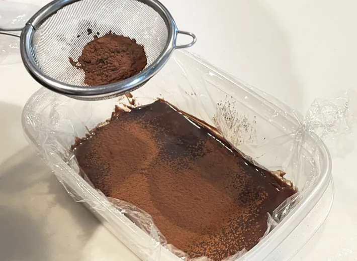 完成した生チョコ風のスイーツにココアパウダーをかける写真（撮影：grapeフード編集部）