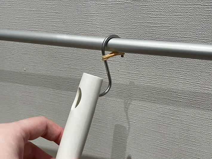 S字フックにかけた掃除道具を取ろうとする写真（撮影：grapeライフハック編集部）