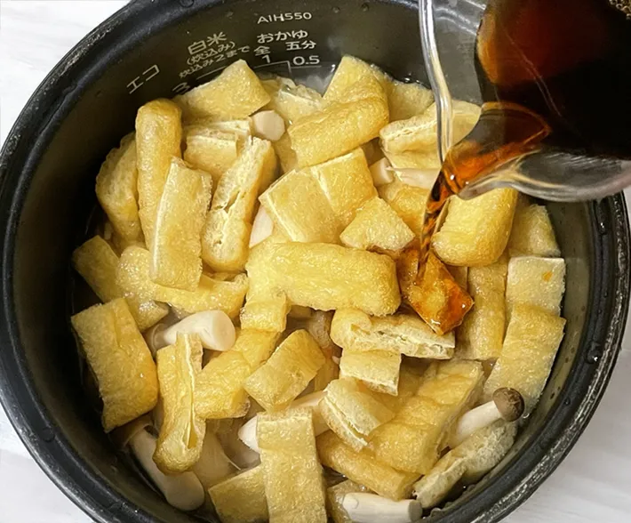 炊飯器に炊き込みご飯の具材を入れる写真（撮影：grapeフード編集部）