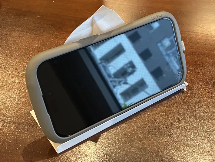 ノート用紙で作ったスマホスタンドに乗せたスマホ（撮影：grapeライフハック編集部）