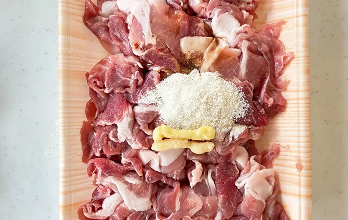 豚こま肉のパックに、鶏ガラスープの素、塩、醤油、ショウガチューブ、ニンニクチューブを入れた画像（撮影：エニママ）