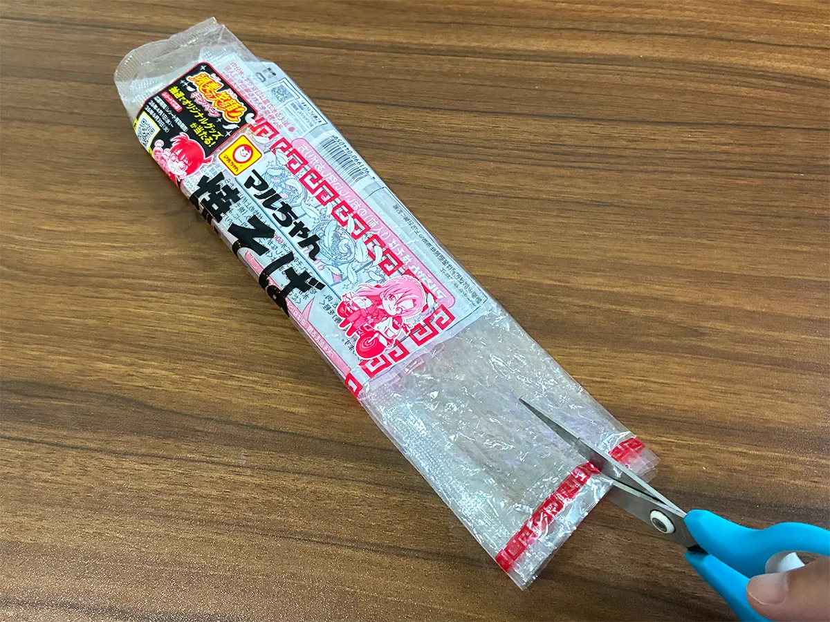 焼きそば袋に切れ込みを入れる場面(撮影:grapeライフハック編集部)