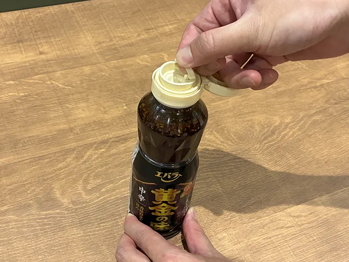 焼き肉のタレを真上に引っ張って開ける場面（撮影：grapeライフハック編集部）