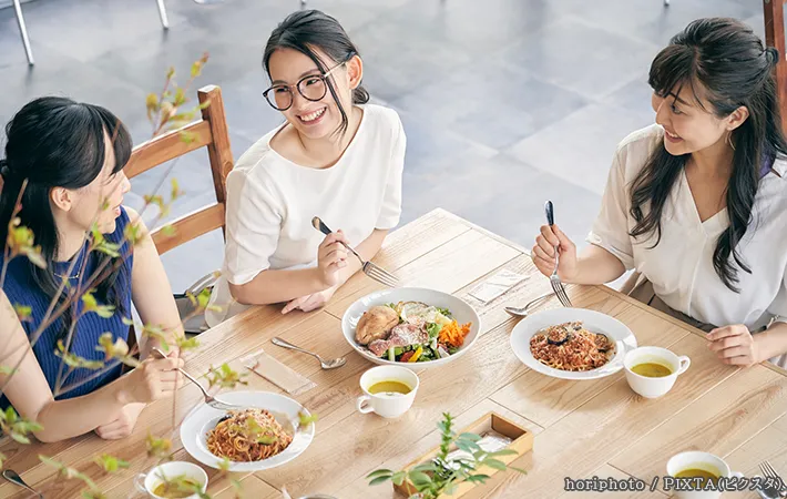 楽しそうに食事をする3人の女性の写真