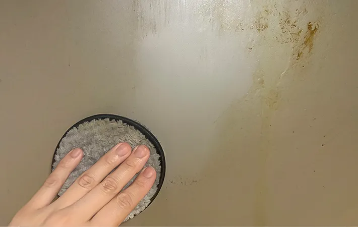 油汚れのついた壁を掃除する写真