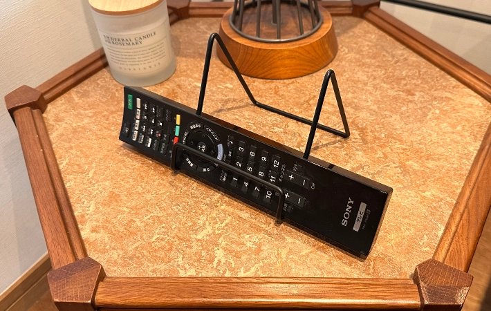 ワイヤースタンドにテレビのリモコンを立てかけている写真（撮影：grapeライフハック編集部）