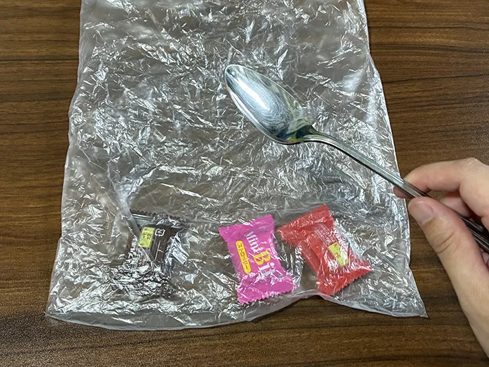 机に置かれたポリ袋と、指で持ったスプーン（撮影：grapeライフハック編集部）