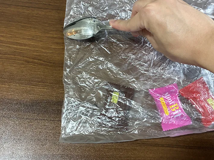 スプーンでポリ袋をこする場面（撮影：grapeライフハック編集部）