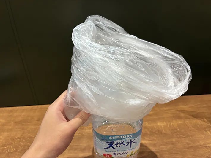 まとめたポリ袋をペットボトルからはずす場面（撮影：grapeライフハック編集部）