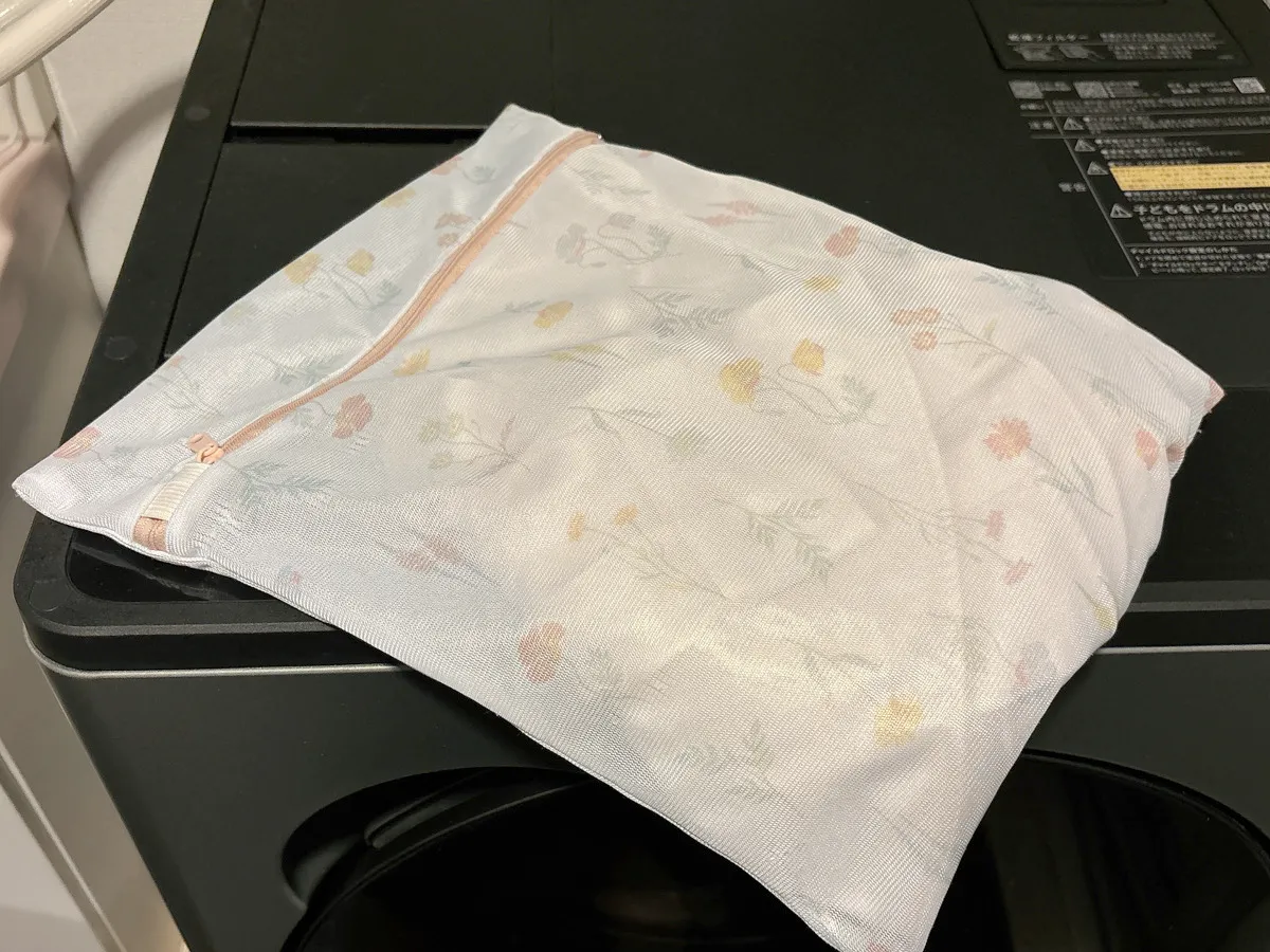 洗濯ネットの写真が洗濯機の上に載っている（撮影：grapeライフハック編集部）