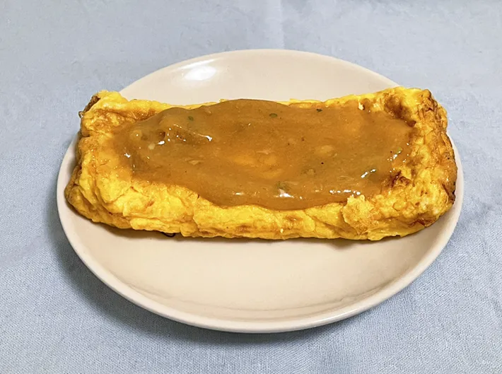 『うどんスープマヨ』を玉子焼きにかける写真（撮影：grapeフード編集部）
