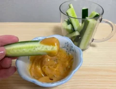 キュウリを『うどんスープマヨ』につけて食べる写真（撮影：grapeフード編集部）